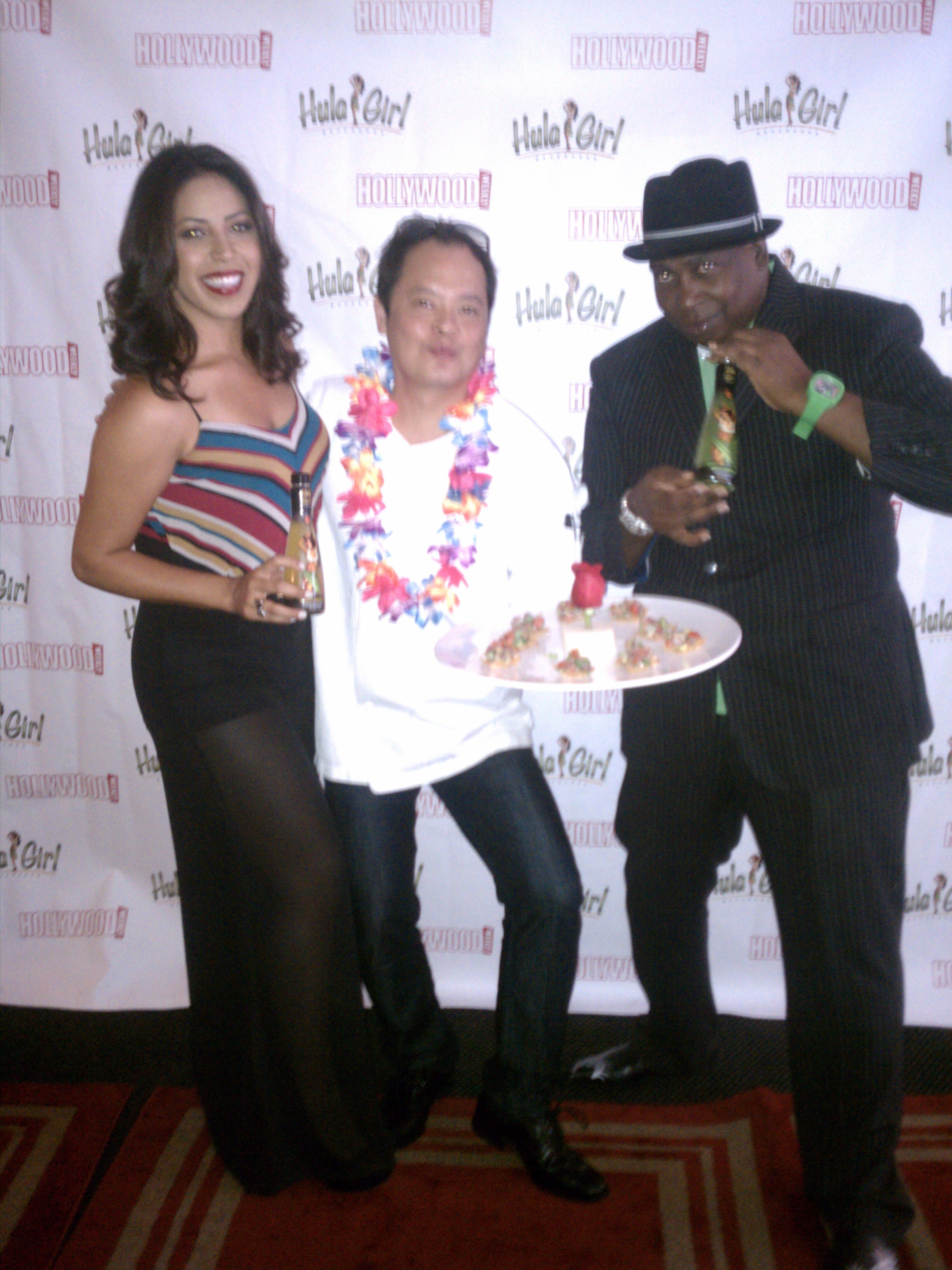 From left to right, Rosemary Lopez, the official Hula Girl, Chef Jack Lee and Hula Girl's brand ambassador, BJ Drake pose on the red carpet with sushi and Hula Girl products 