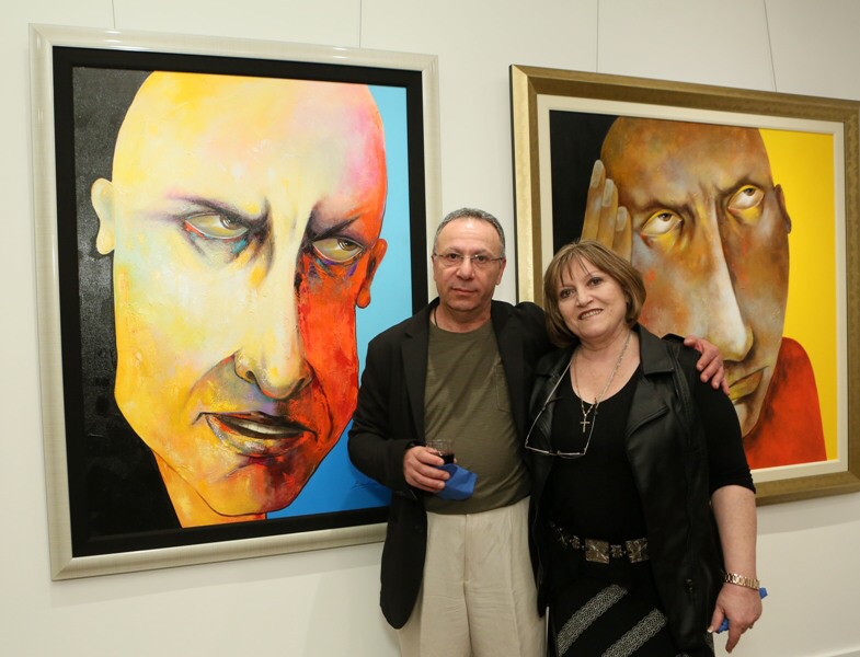 Ara Berberyan with wife in front of his paintings.